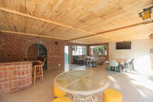 a living room with a table and a brick wall at The Valley Escape - Executive Suite in Gqeberha