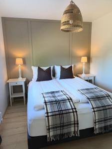 a bedroom with a large white bed with two tables at Granastaðir Guesthouse in Granastaðir