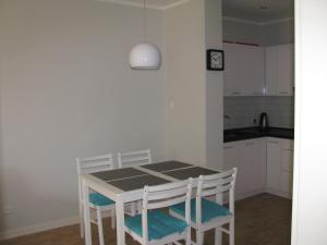 a kitchen with a table and chairs and a clock at Blue Mare Apartament u Kwiatków in Łukęcin