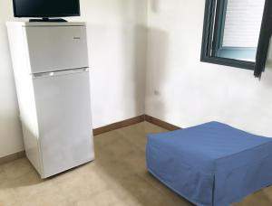 a room with a refrigerator and a blue ottoman at Camping Porto Miggiano in Santa Cesarea Terme