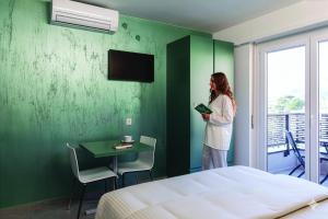 a woman standing in a room with a green wall at By THE LAKE in Muralto