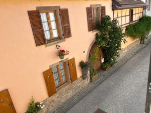 a building with wooden doors and windows on a street at BELISAMA in Molsheim