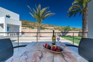 a bowl of fruit on a table with a bottle of wine at Prasonisi Lighthouse Asimenis in Prasonisi