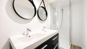 a white bathroom with a sink and mirror at Le Clos Delobel in Tourcoing
