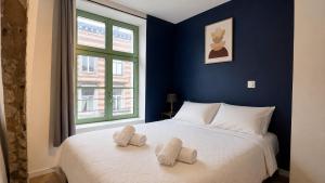 a blue bedroom with a bed with two pillows on it at Le Clos Delobel in Tourcoing +14 photos