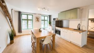 a kitchen with a wooden table and white cabinets at Le Clos Delobel in Tourcoing