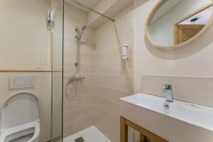 a bathroom with a shower and a sink and a mirror at Le Bellacha in La Léchère