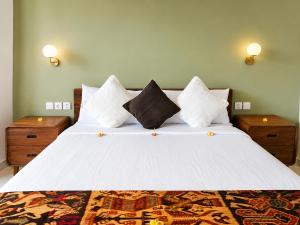 a bedroom with a large bed with white sheets and pillows at Padmasari Guest House in Canggu +36 photos