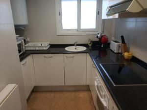 a kitchen with a sink and a counter top at Costadaurada2000 Sunset Beach Cunit in Cunit +11 photos