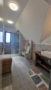 a bathroom with a tub and a toilet and a sink at Casa Comilor in Şurdeşti +24 photos