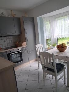 a kitchen with a table and two chairs and a table and a kitchen with at Ferienwohnung Silvia in Steinhagen