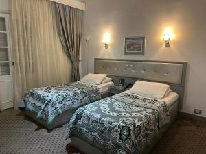 a hotel room with two beds and a window at Revira Palace - Marsa Matrouh in Marsa Matruh