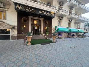 a building with a patio with umbrellas in front of it at Revira Palace - Marsa Matrouh in Marsa Matruh