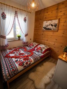 a bedroom with a bed and a window at Osada Zawóz domki z balią jacuzzi i sauną nad Jeziorem Solińskim in Zawóz +76 photos