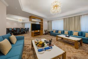 a living room with blue couches and a television at The Venue Al Harithia Hotel in Medina