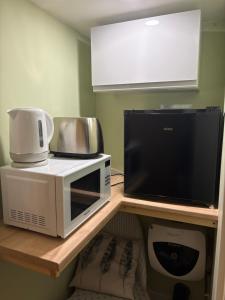 a microwave and a coffee maker on a shelf at The Garden Studio in Wargrave