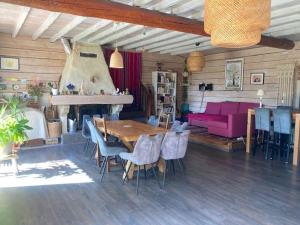 a living room with a table and a pink couch at L'Abeille-Vie in Tréziers