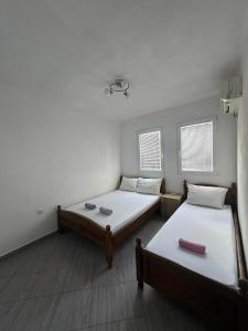 a room with two beds and two windows at Apartmani Glory Sutomore in Sutomore