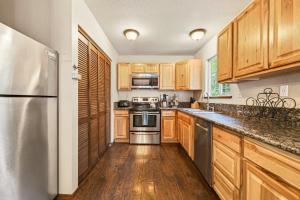 a kitchen with wooden cabinets and a stainless steel refrigerator at The Rustic Pine 2BDR Cabin in Tahoma
