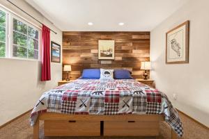 a bedroom with a bed with a wooden accent wall at The Rustic Pine 2BDR Cabin in Tahoma
