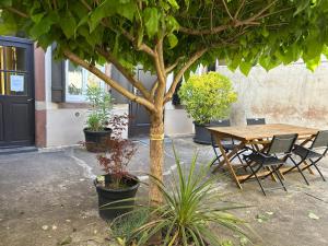 a wooden table and chairs next to a tree at BELISAMA in Molsheim