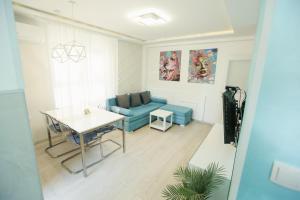 a living room with a blue couch and a table at Apartmani SLEEP&JOY in Zlatibor