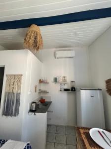 a kitchen with white walls and a blue ceiling at Suite Canoa azul 1 in Aracati