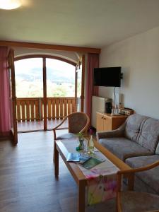 a living room with a couch and a table at Hotel Lugerhof in Weiding