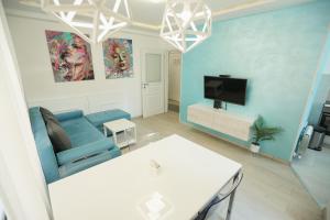 a living room with a blue couch and a tv at Apartmani SLEEP&JOY in Zlatibor