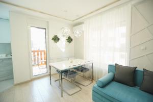 a living room with a blue couch and a table at Apartmani SLEEP&JOY in Zlatibor