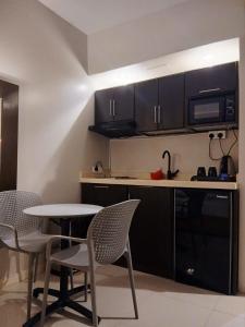 a kitchen with black cabinets and a table and chairs at شقق نزل التوت للشقق المخدومة in Al Kharj