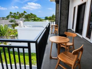 a balcony with a bar with chairs and a view of the ocean at Padmasari Guest House in Canggu