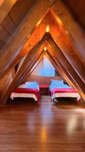 ein Dachzimmer mit zwei Betten und einem Fenster in der Unterkunft Montlude in Bossost