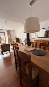 eine Küche und ein Esszimmer mit einem Holztisch und Stühlen in der Unterkunft Montlude in Bossost