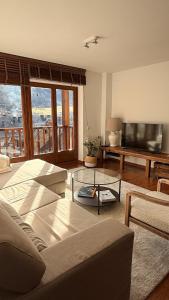 ein Wohnzimmer mit Sofa und Flachbildfernseher in der Unterkunft Montlude in Bossost
