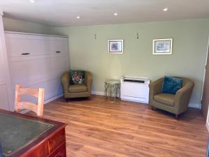 a living room with two chairs and a table at The Garden Studio in Wargrave +2 photos