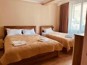 two beds in a bedroom with towels on them at OR-Ni in Borjomi