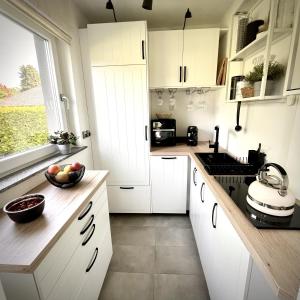 a kitchen with white cabinets and a bowl of fruit on the counter at Koje47 in Scharbeutz