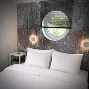 a bedroom with a large white bed with a window at Koje47 in Scharbeutz