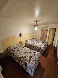 a room with two beds in a room at Rosa De Los Vientos in Ushuaia