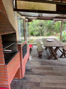a patio with a picnic table and a brick oven at Espaço Colibri in Teresópolis