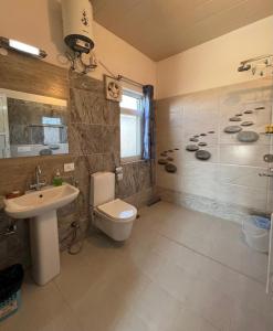 a bathroom with a toilet and a sink and a shower at Dalipfarm River View Guestroom in Surajpur +6 photos