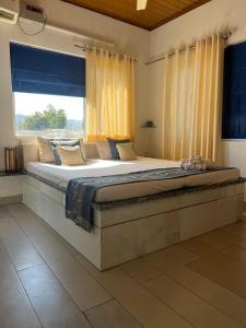 a large bed in a room with a large window at Dalipfarm River View Guestroom in Surajpur