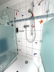 a bathroom with a shower with stickers on the wall at Ferien-Whg Stünkel nahe Steinhuder Meer mit Garten und Balkon in Steinhude +47 photos