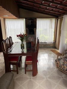 a dining room with a wooden table and chairs at Espaço Colibri in Teresópolis +8 photos