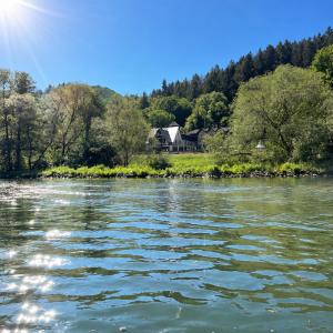 a house on the banks of a river at Hotel-Restaurant Peifer in Brodenbach