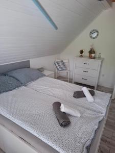 a bedroom with a bed with towels and a dresser at Őrségi Csónakház in Hegyhátszentjakab