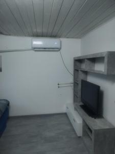 a room with a flat screen tv on a shelf at Apartman M&D in Pančevo