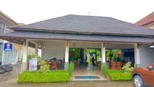 a house with a porch with chairs and a car at Melati Hotel central kuta mandalika in Kuta Lombok