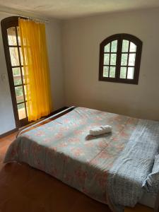 a bedroom with a bed with two towels on it at Espaço Colibri in Teresópolis
